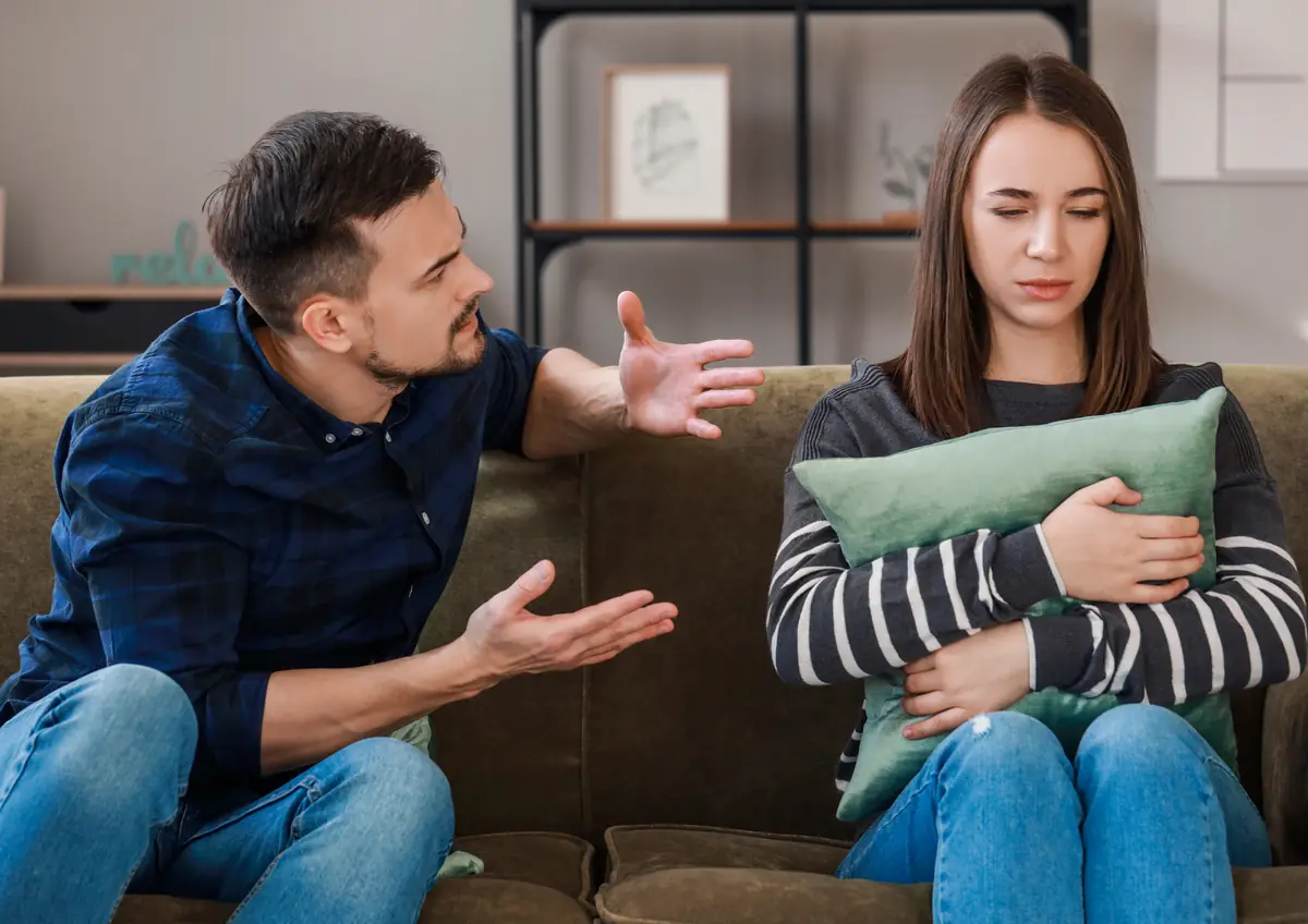 Casal discutindo no sofá